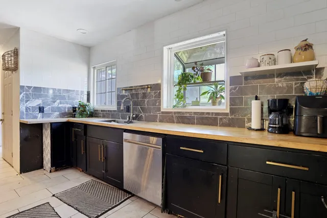 a kitchen with stainless steel appliances granite countertop a sink stove and cabinets