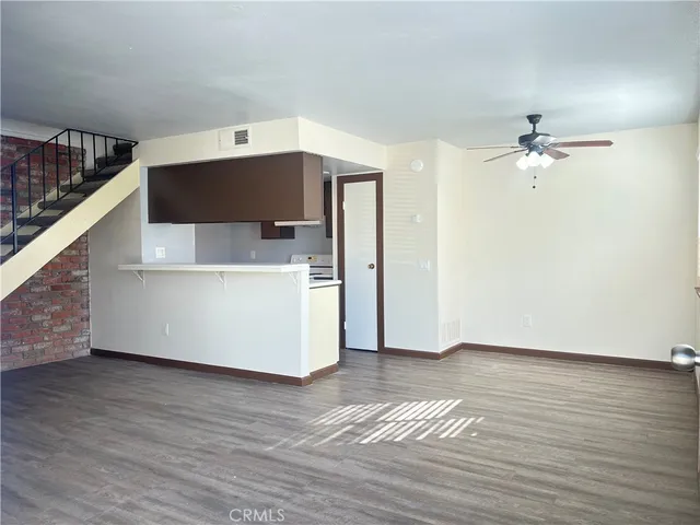a view of a livingroom with a ceiling fan and wooden floor