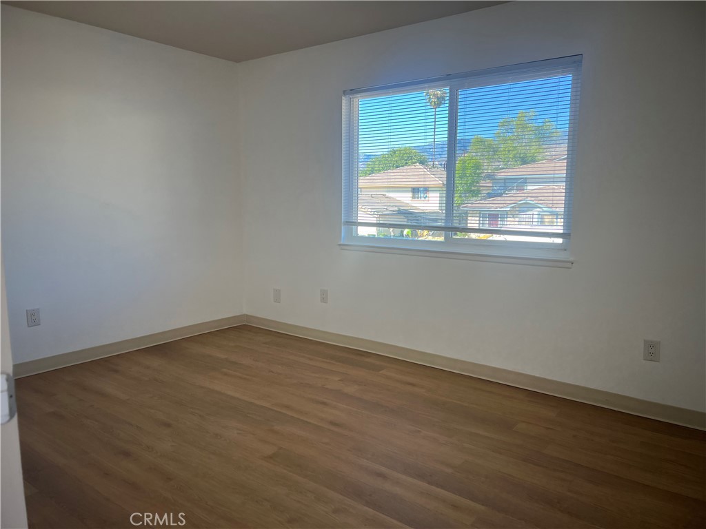 3535 20th Street Highland, CA 92346 - Photo 8 of 14 an empty room with wooden floor and windows