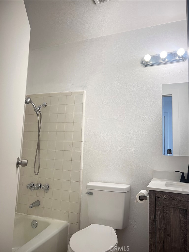 3535 20th Street Highland, CA 92346 - Photo 10 of 14 a bathroom with a toilet a sink a mirror and vanity