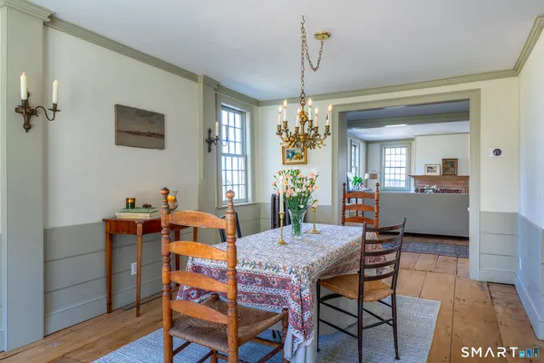 a dining room with furniture a chandelier and wooden floor