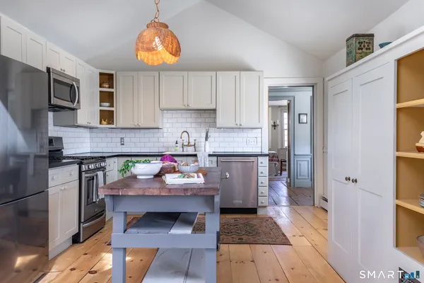 a kitchen with a refrigerator and a stove top oven