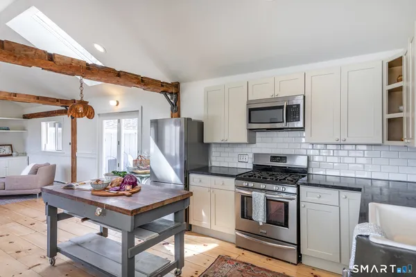 a kitchen with stainless steel appliances a stove a sink a microwave a refrigerator and cabinets