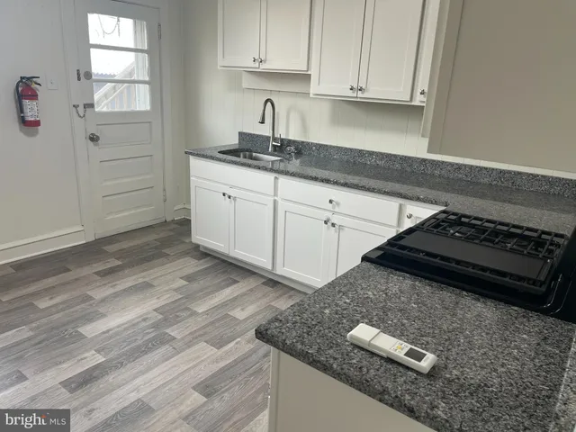 a kitchen with granite countertop a stove and cabinets