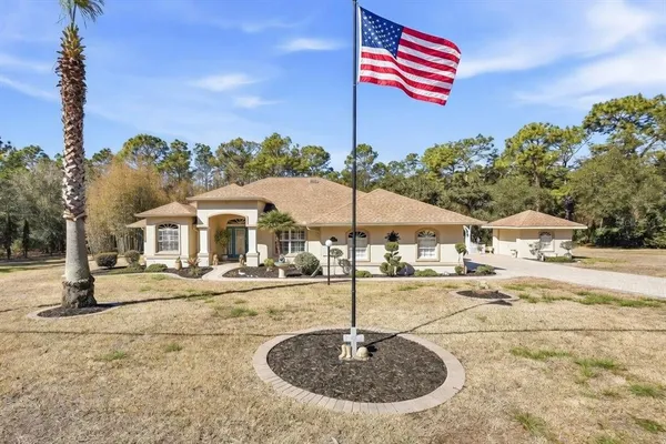 a front view of a house with a yard and trees