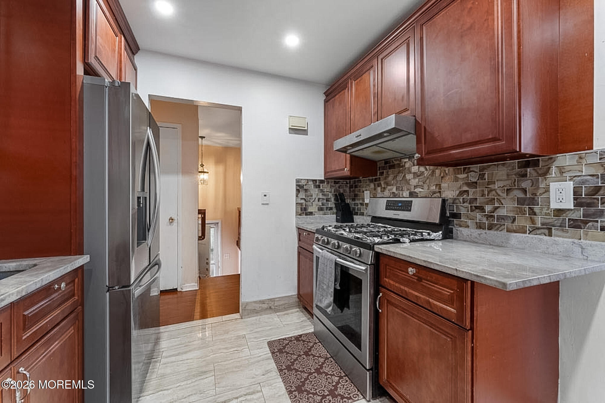9 Neal Street Jackson, NJ 08527 - Photo 13 of 35 a kitchen with stainless steel appliances granite countertop a stove top oven a sink dishwasher and a refrigerator with wooden cabinets