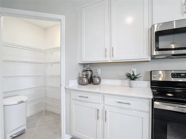 a kitchen with stainless steel appliances granite countertop white cabinets a stove a sink and dishwasher