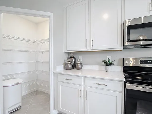 a kitchen with stainless steel appliances granite countertop white cabinets a stove a sink and dishwasher