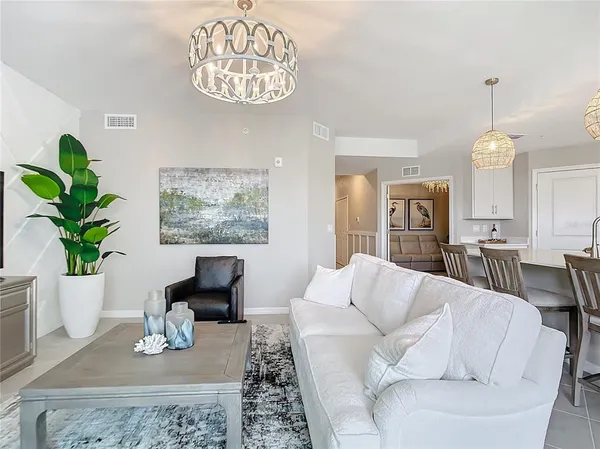 a living room with furniture a chandelier and a window
