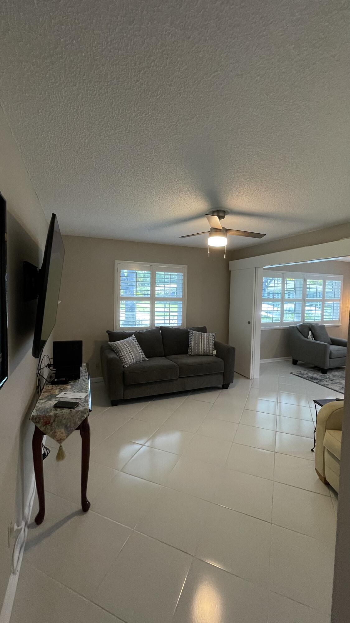 10140 South 44th Drive, Unit 372 Boynton Beach, FL 33436 - Photo 6 of 19 a living room with furniture and a flat screen tv