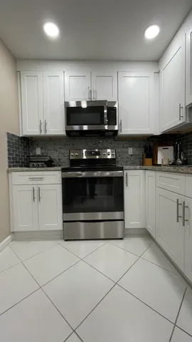 a kitchen with granite countertop a stove sink and cabinets