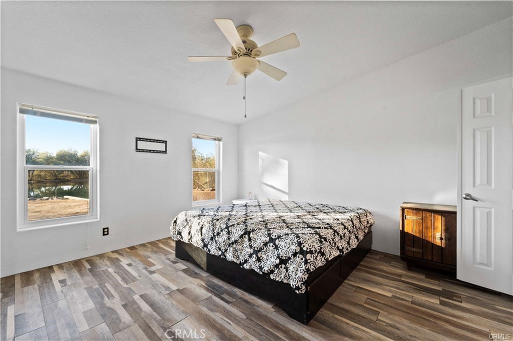 34232 Maui Road Newberry Springs, CA 92365 - Photo 14 of 35 a bedroom with a bed next to a window with a flat screen tv