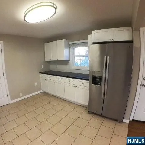 a kitchen with granite countertop cabinets and refrigerator