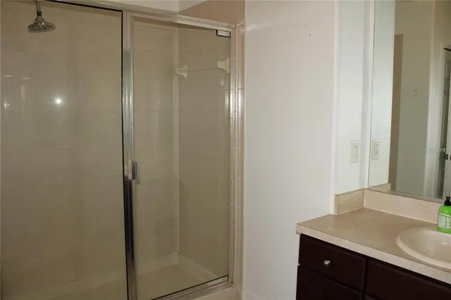 a bathroom with a granite countertop sink vanity and shower
