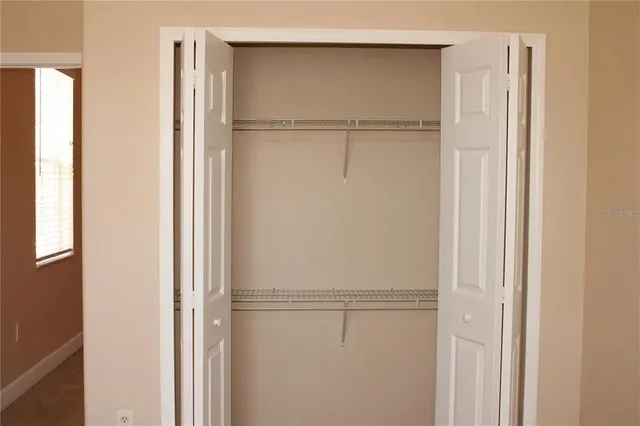 a view of walk in closet with empty racks