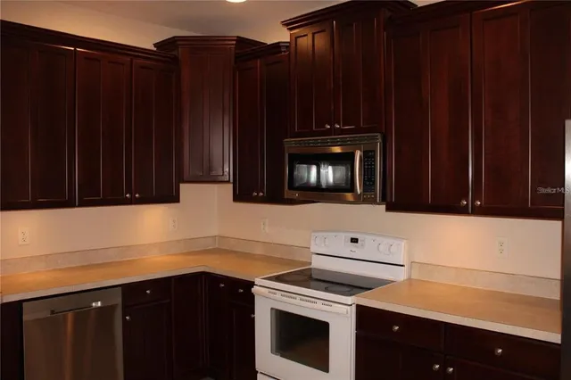 a kitchen with wooden cabinets and black appliances
