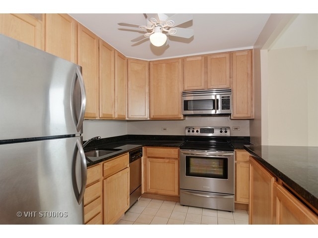 1850 North Clark Street, Unit 2801 Chicago, IL 60614 - Photo 4 of 10 a kitchen with granite countertop a refrigerator stove and microwave