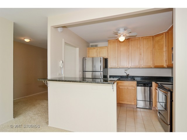 1850 North Clark Street, Unit 2801 Chicago, IL 60614 - Photo 5 of 10 a kitchen with stainless steel appliances granite countertop a sink refrigerator and cabinets