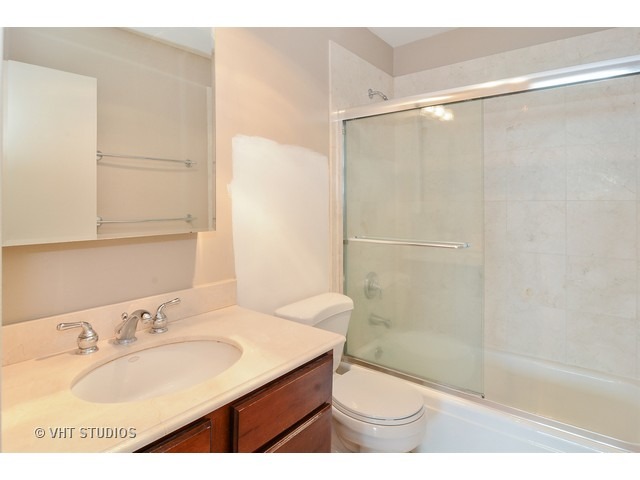 1850 North Clark Street, Unit 2801 Chicago, IL 60614 - Photo 8 of 10 a bathroom with a granite countertop sink a toilet and shower