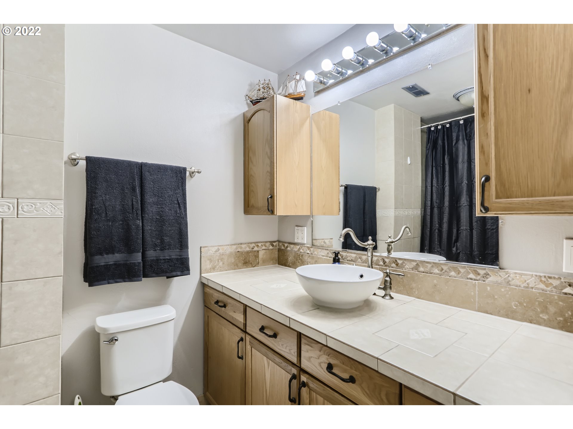 490 Southwest 4th Street Gresham, OR 97080 - Photo 18 of 30 a bathroom with a sink a toilet a mirror a vanity and shower