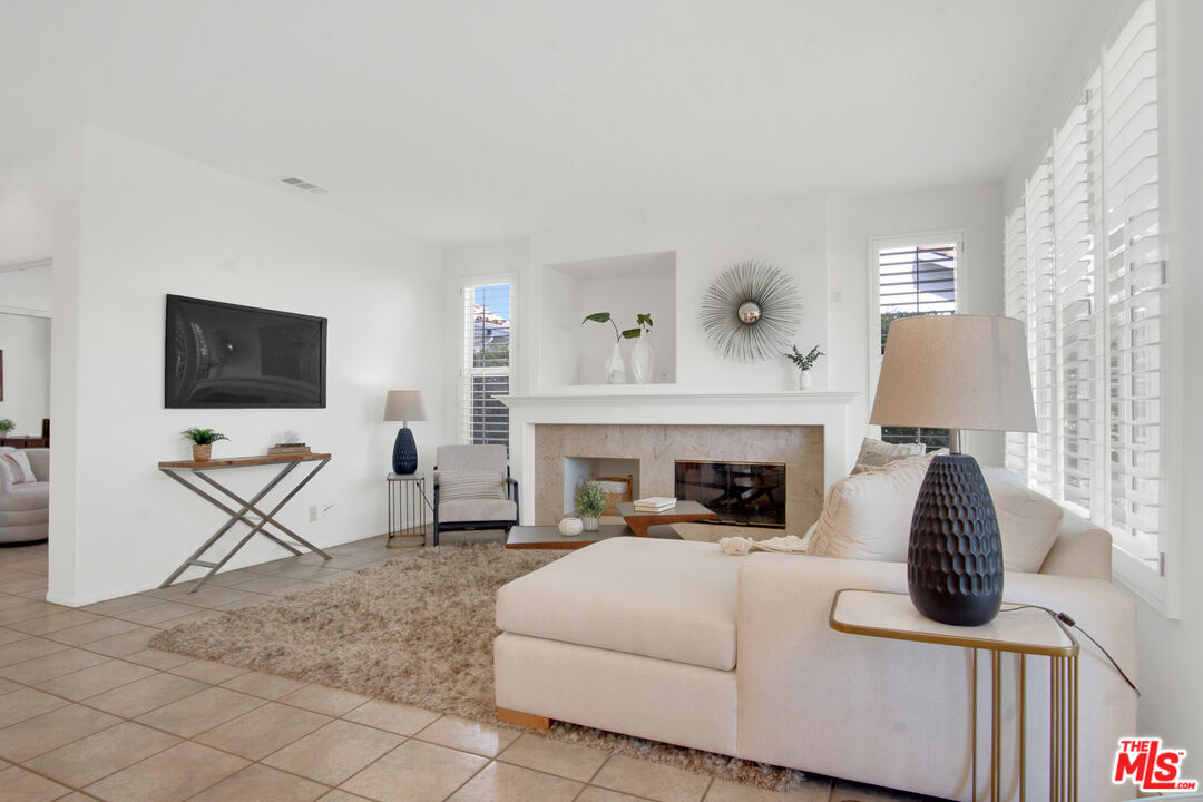 59 La Perla Foothill Ranch, CA 92610 - Photo 25 of 60 a living room with furniture a flat screen tv and a fireplace