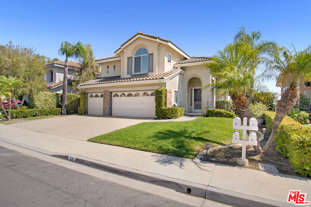 59 La Perla Foothill Ranch, CA 92610 - Photo 3 of 60 a front view of a house with a garden and plants