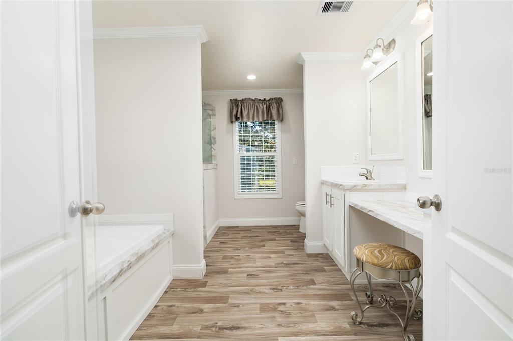 689 Eagle Watch Road Oak Hill, FL 32759 - Photo 15 of 32 a spacious bathroom with a tub sink and mirror