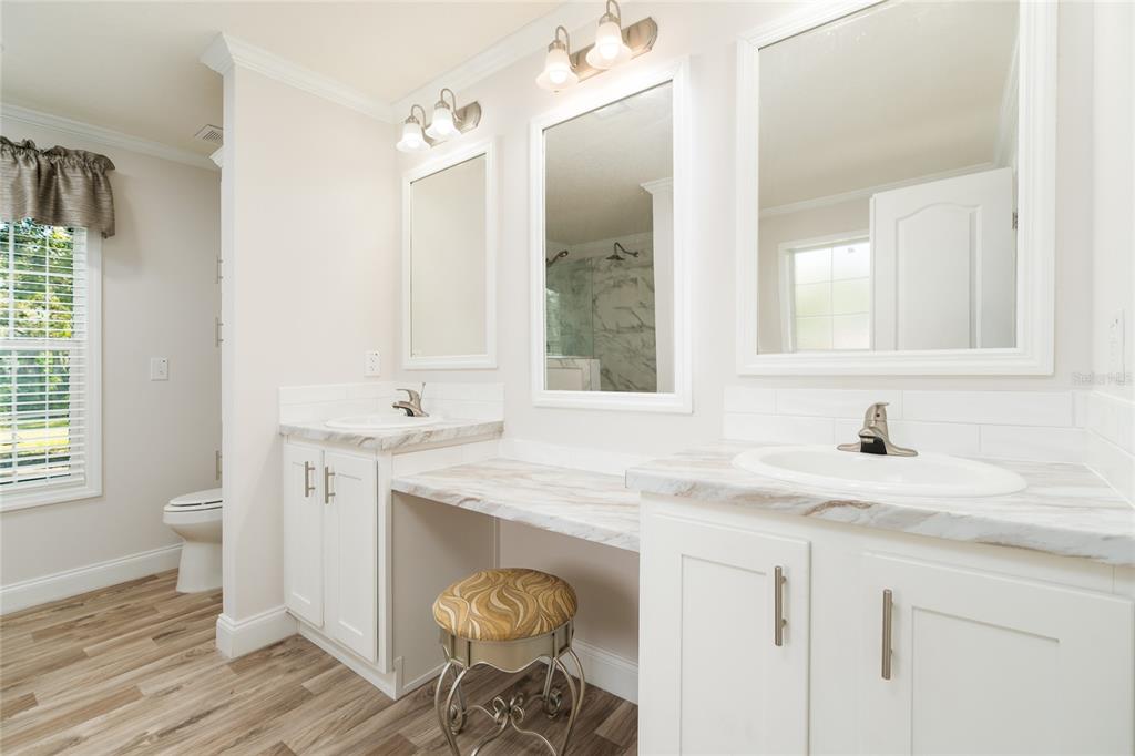 689 Eagle Watch Road Oak Hill, FL 32759 - Photo 16 of 32 a bathroom with a granite countertop sink a toilet and a mirror