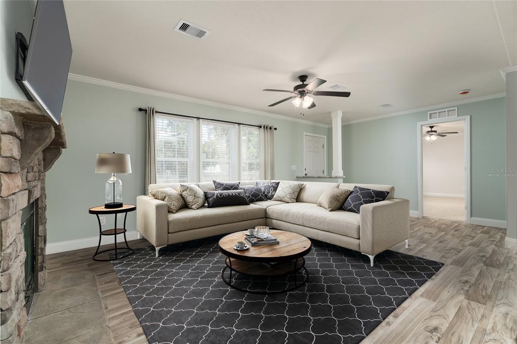 689 Eagle Watch Road Oak Hill, FL 32759 - Photo 4 of 32 a living room with furniture a large window and a flat screen tv