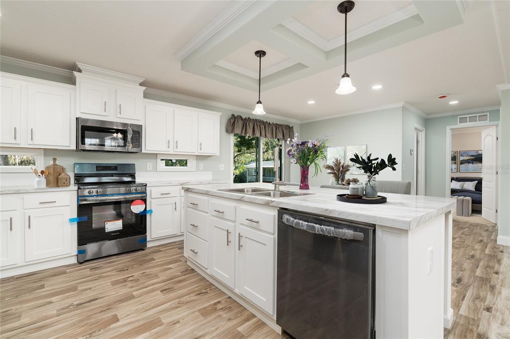 689 Eagle Watch Road Oak Hill, FL 32759 - Photo 10 of 32 a kitchen with kitchen island granite countertop stainless steel appliances cabinets a sink and a wooden floor