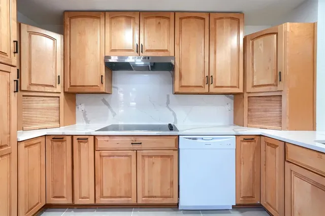a kitchen with granite countertop white cabinets and white appliances