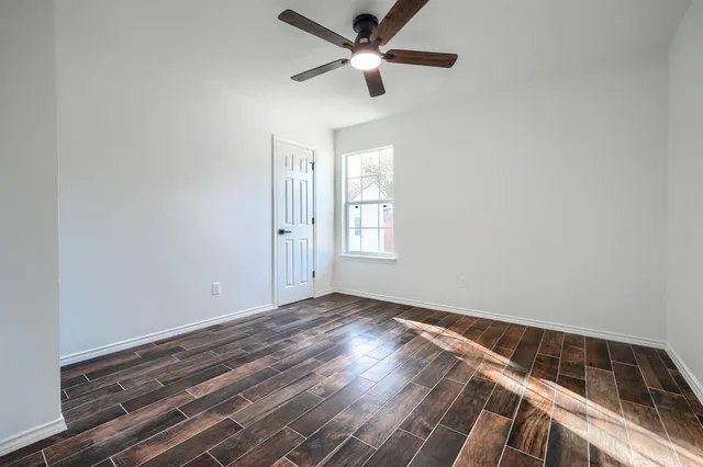 a view of empty room with window and ceiling fan