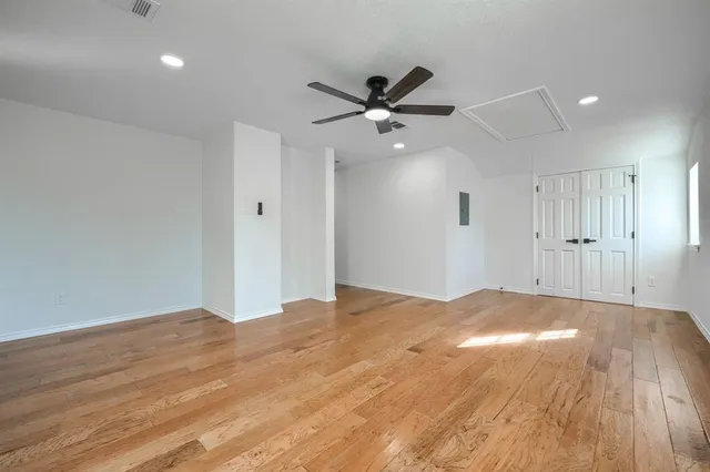 a bedroom with a bed a couch and a flat screen tv