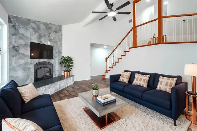 a living room with furniture a flat screen tv and a fireplace