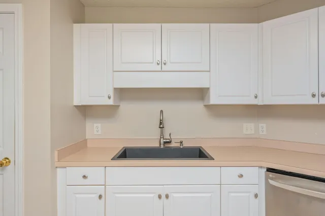 a kitchen with white cabinets and a sink