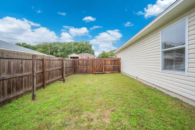 a view of a backyard with wooden fence