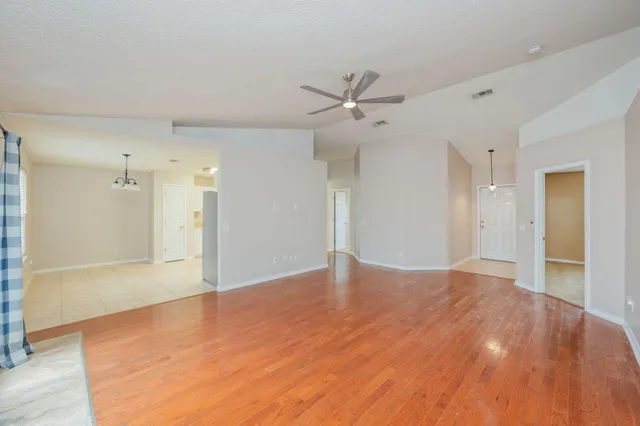 a view of a big room with wooden floor and a ceiling fan