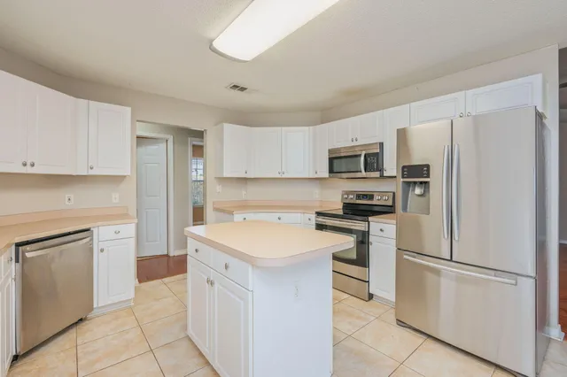 a kitchen with white cabinets and stainless steel appliances