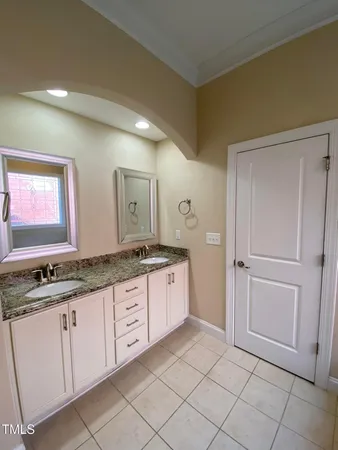 a spacious bathroom with a granite countertop sink and a mirror