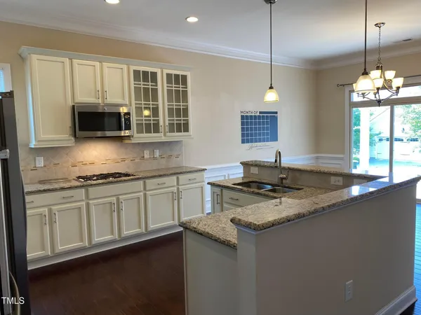 a kitchen with stainless steel appliances granite countertop a sink stove and microwave
