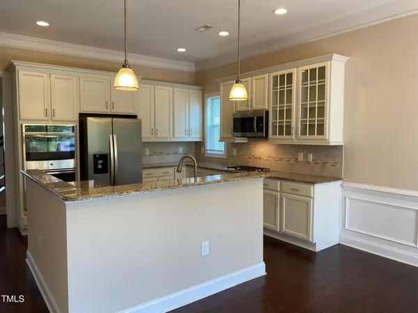 a kitchen with stainless steel appliances granite countertop a refrigerator a sink and a stove