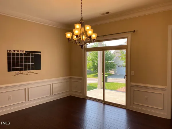 a view of a livingroom with a chandelier fan and a window
