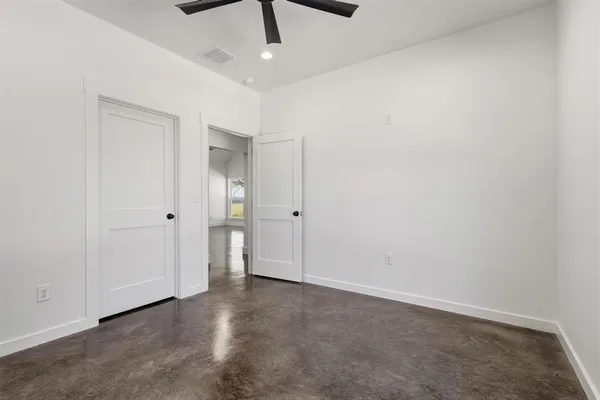 an empty room with a ceiling fan and carpet