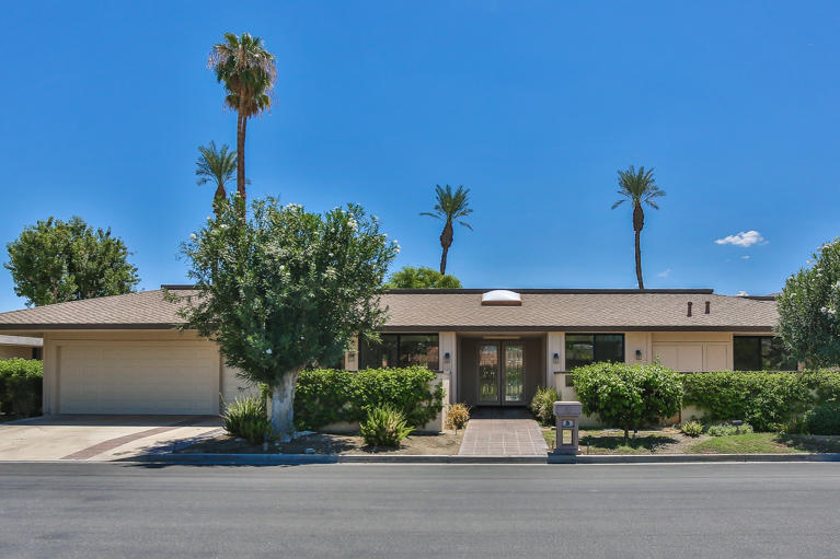 49 Columbia Drive Rancho Mirage, CA 92270 - Photo 2 of 52 a front view of a house with a yard
