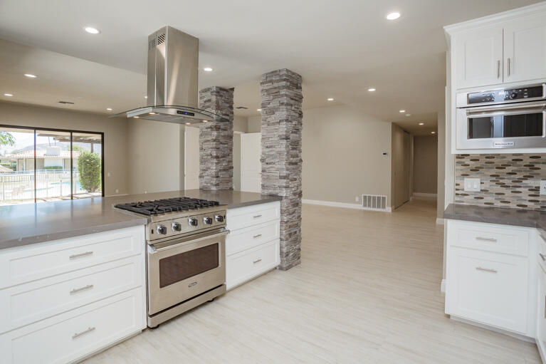 49 Columbia Drive Rancho Mirage, CA 92270 - Photo 6 of 52 a kitchen with stainless steel appliances white cabinets and a stove