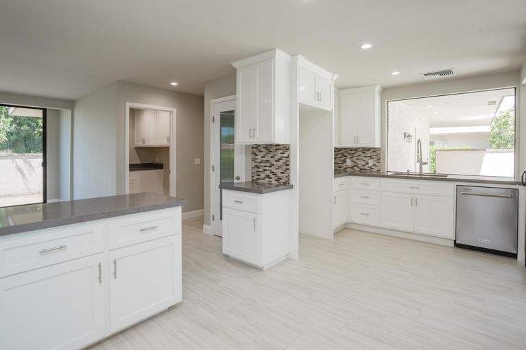 49 Columbia Drive Rancho Mirage, CA 92270 - Photo 8 of 52 a large white kitchen with a sink a window and stainless steel appliances
