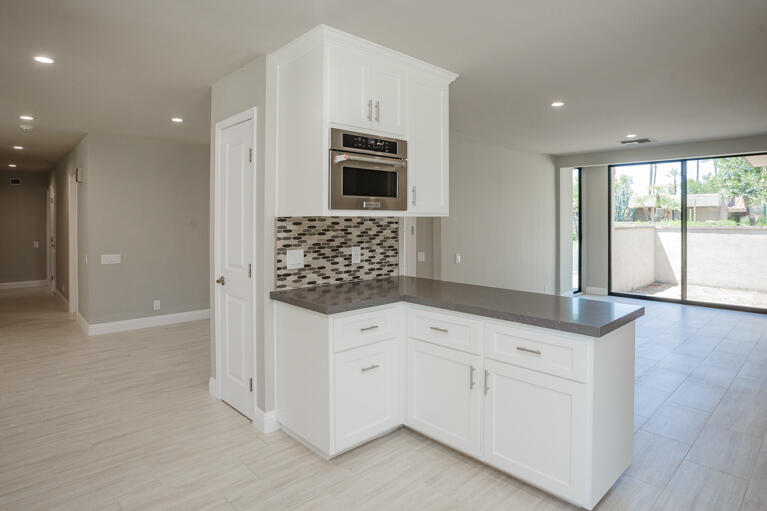 49 Columbia Drive Rancho Mirage, CA 92270 - Photo 10 of 52 a kitchen with granite countertop white cabinets and stainless steel appliances