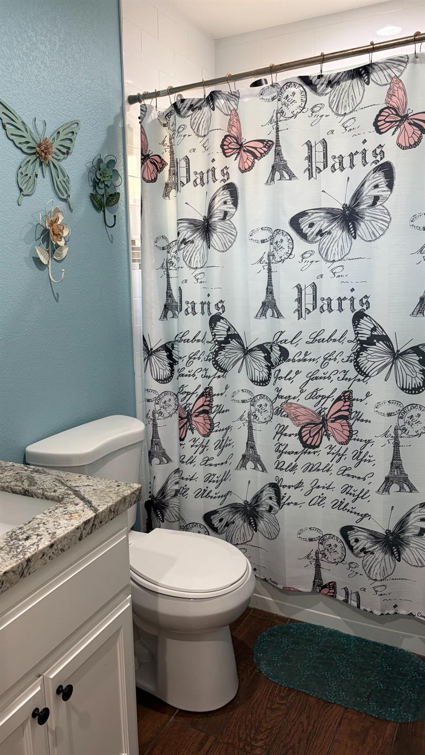 3105 Keller Street Modesto, CA 95355 - Photo 11 of 25 a bathroom with a toilet and a shower curtain
