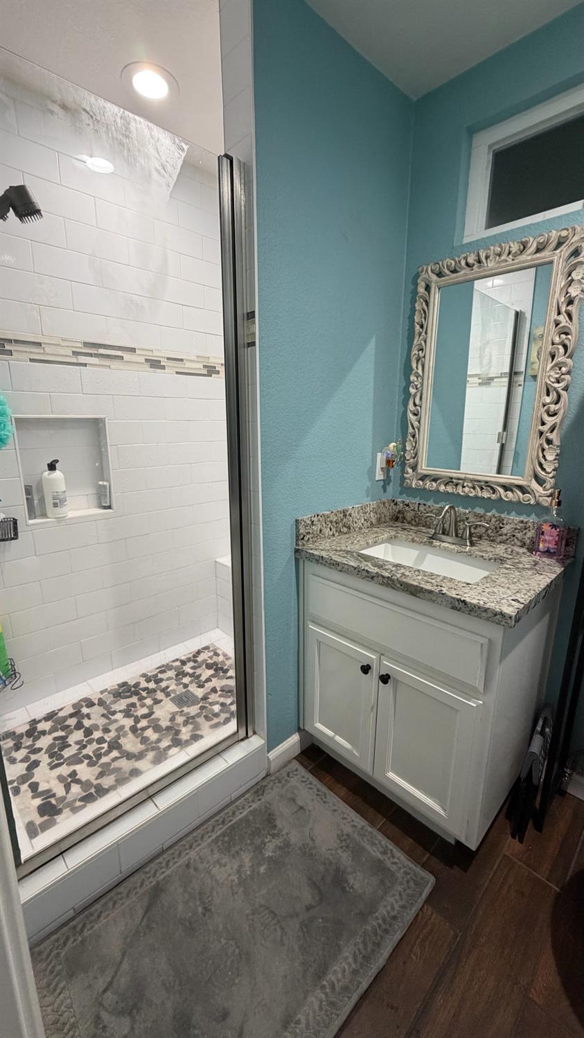 3105 Keller Street Modesto, CA 95355 - Photo 18 of 25 a bathroom with a granite countertop sink a toilet a shower and a mirror