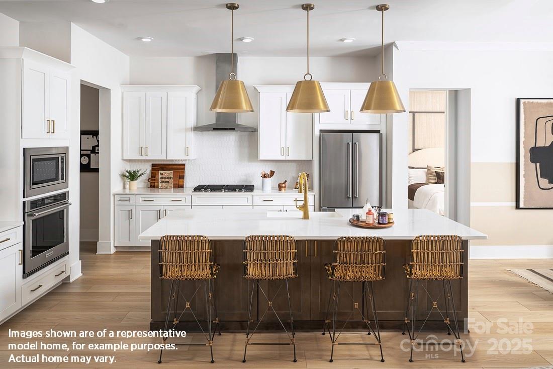 1049 Pinecone Avenue, Unit 218 Indian Land, SC 29707 - Photo 6 of 21 a kitchen with stainless steel appliances kitchen island granite countertop a table chairs microwave and sink